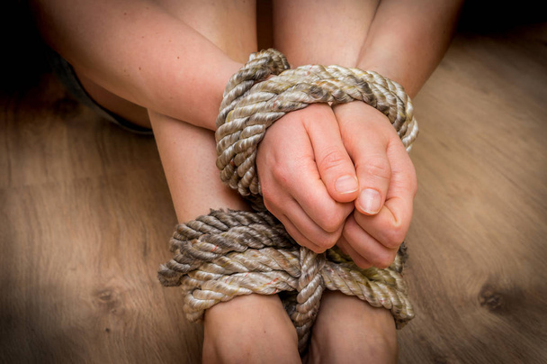 Entführte Frau mit Seil auf Holzboden gefesselt - Foto, Bild