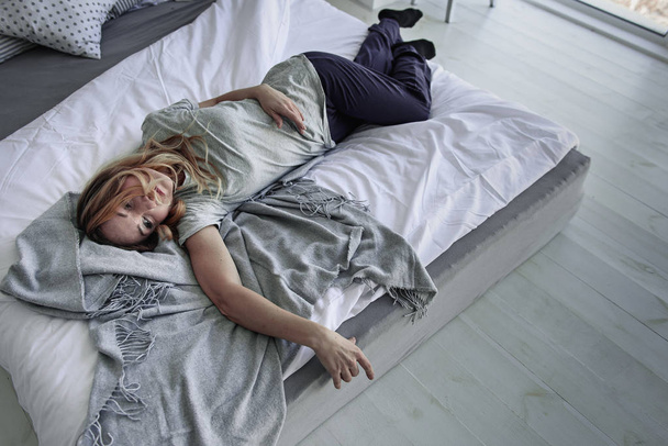 Suffering female person lying on bed - Φωτογραφία, εικόνα