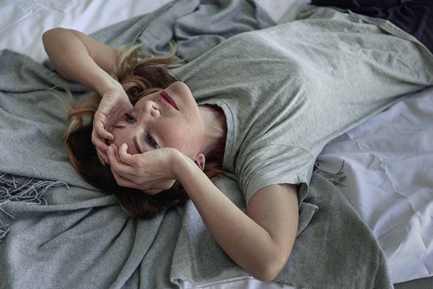 Desponded osoba płci żeńskiej, leżącego w sypialni - Zdjęcie, obraz