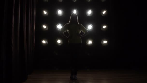 Silhouet van een meisje dansen op de achtergrond-verlichting. - Video