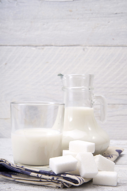 UG και ποτήρι με το γάλα και τα σάκχαρα - Φωτογραφία, εικόνα