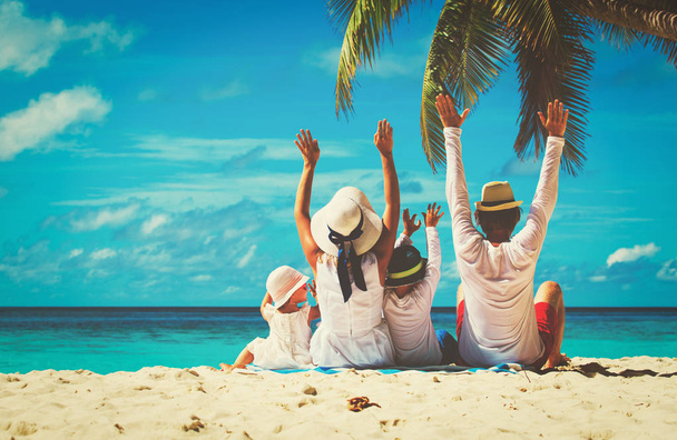 família feliz com duas crianças mãos para cima na praia
 - Foto, Imagem