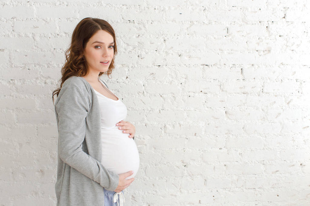 Femme enceinte posant en regardant la caméra
 - Photo, image