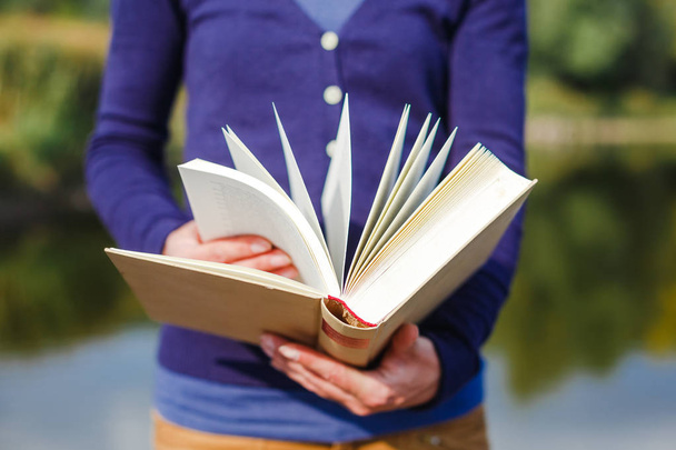 Close-up of female hands holding open book. Reading concept - Photo, Image