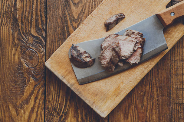 Couteau de coupe tranchant steak grillé sur planche de bois de coupe de viande
 - Photo, image