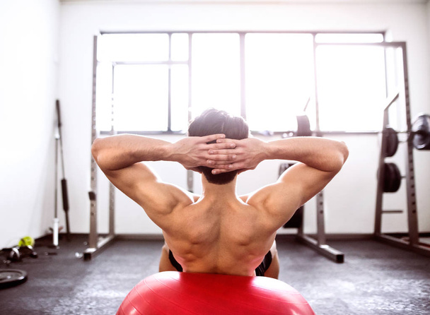 Fit hispanic man in gym training, working abs, doing crunches - Fotó, kép