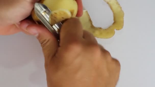 Men's hands cut peel potato, metal knife. - Filmati, video
