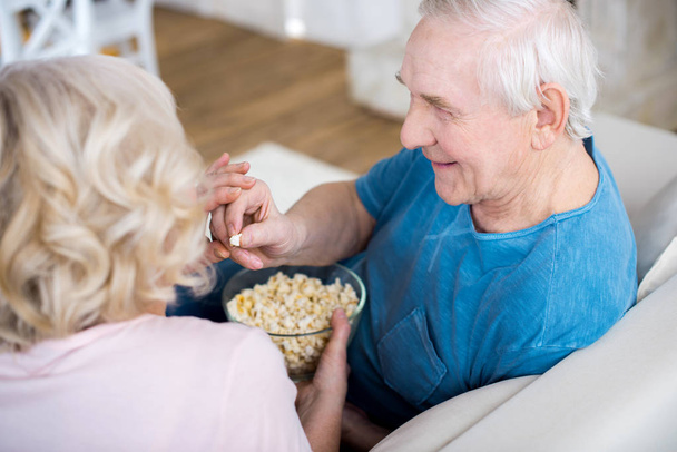 Vanhempi pari syö popcornia
 - Valokuva, kuva