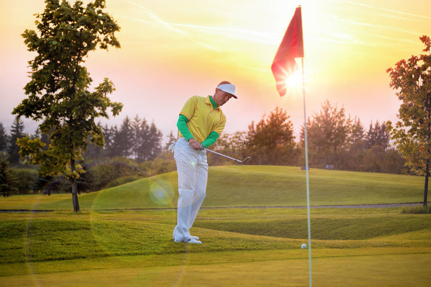 Člověk hraje golf proti barevný západ slunce - Fotografie, Obrázek