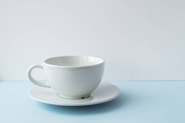 White empty cup for coffee on the blue table - Foto, Imagem