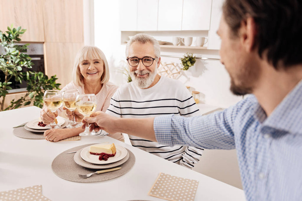 Mature man greeting his parents with wedding anniversary at home - Foto, imagen