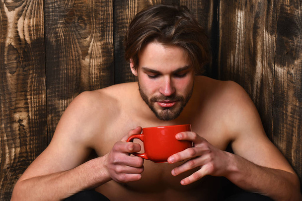 Caucasian bearded sexy macho man holding cup or mug - Foto, Bild