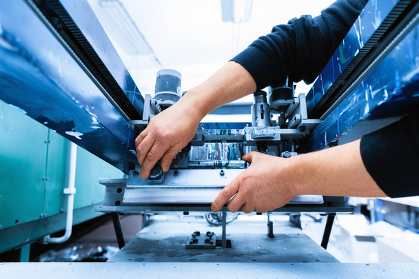 Arbeiter bereitet Drucksiebmaschine vor - Foto, Bild