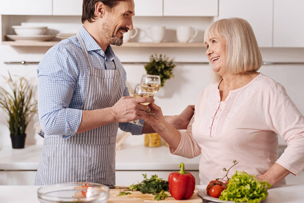 Pleasant man drinking wine with his mother  - Photo, Image