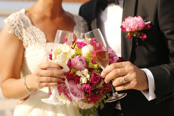 Gorgeous bride and groom holding glasses  - Fotografie, Obrázek