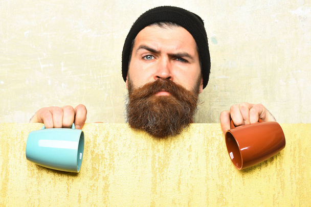 Bearded brutal caucasian hipster with paper sheet and cups - Фото, изображение