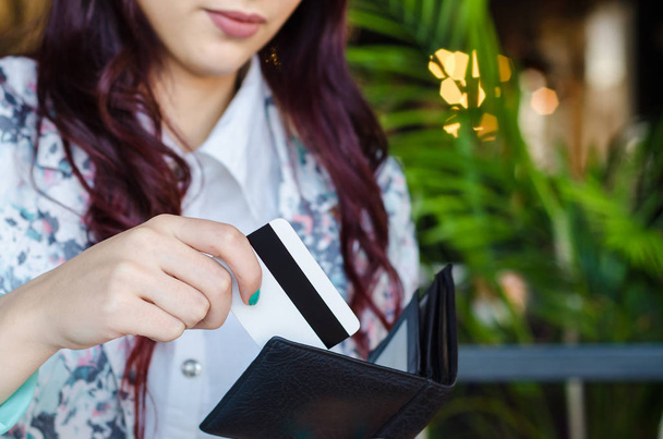 Käufer zieht Kreditkarte aus Brieftasche. - Foto, Bild