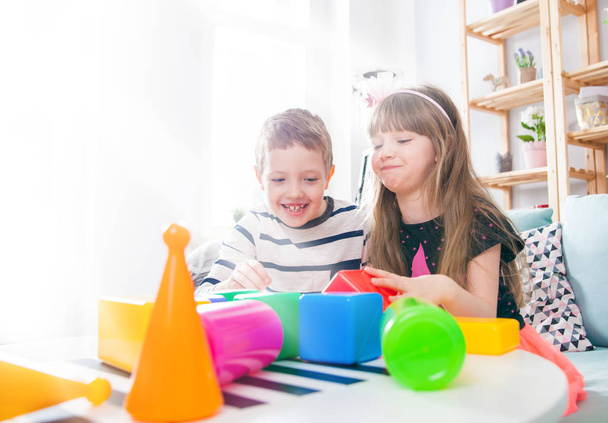 Frères et sœurs jouant avec des blocs colorés à la maison, famille heureuse
 - Photo, image