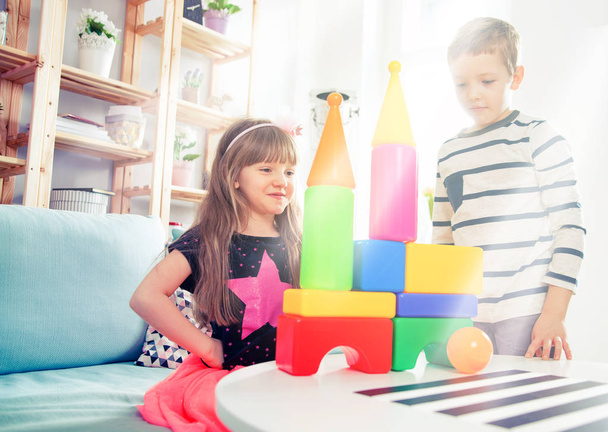 Geschwister spielen zu Hause mit bunten Blöcken, glückliche Familie - Foto, Bild