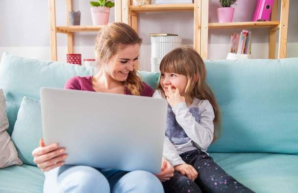 Mother and daughter using laptop together, happy loving family - Φωτογραφία, εικόνα
