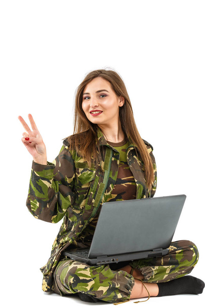Молодая женщина-солдат в военном камуфляже демонстрирует мир
  - Фото, изображение