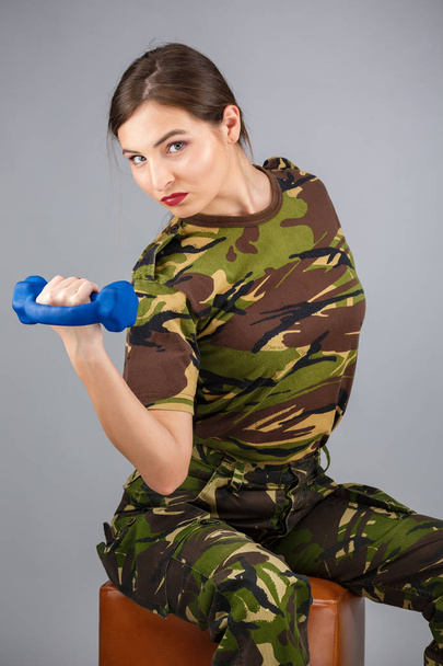 ein sportliches weibliches Fitnessmodel in militärischer Tarnung - Foto, Bild