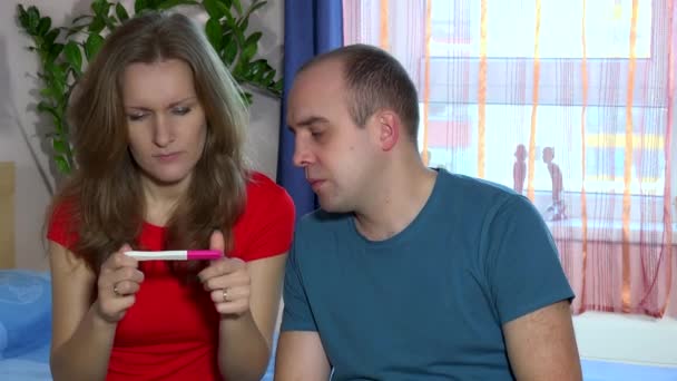 Ideges nő keres a terhességi teszt. Csalódott ember ül mellé - Felvétel, videó