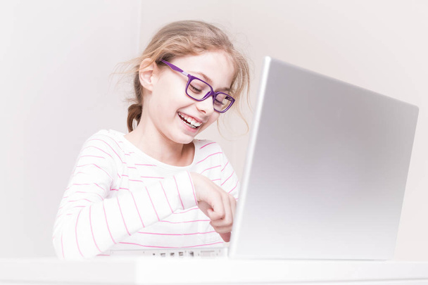 Joyeux sourire enfant fille (enfant) à l'aide d'un ordinateur portable
 - Photo, image