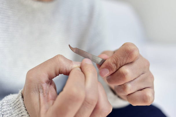 Junger Mann poliert seine Fingernägel - Foto, Bild