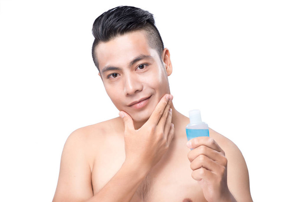 man applying lotion after shave - Фото, изображение