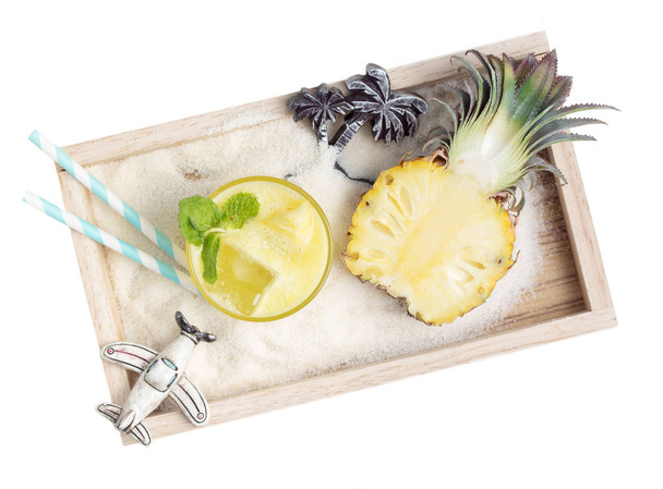 healthy pineapple drink with toys in sand on wooden tray - Φωτογραφία, εικόνα
