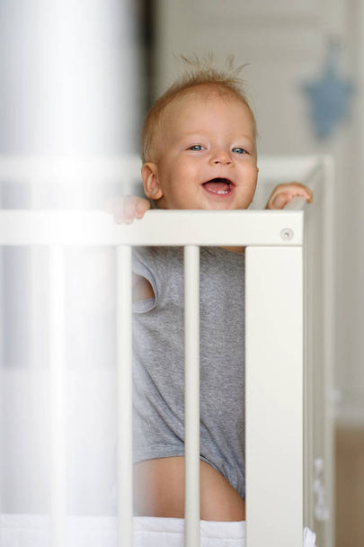 Baby boy standing in crib - Photo, Image