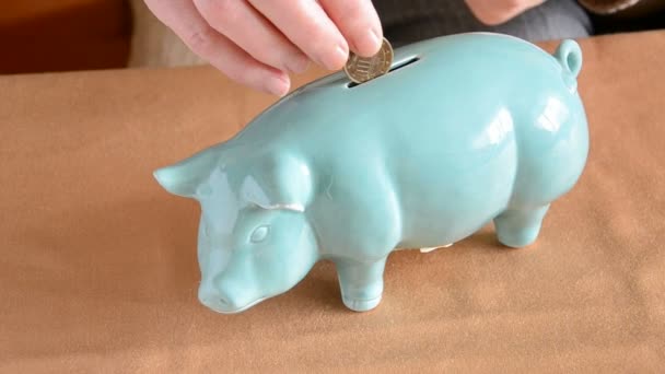 Geld in blaues Sparschwein stecken - Filmmaterial, Video