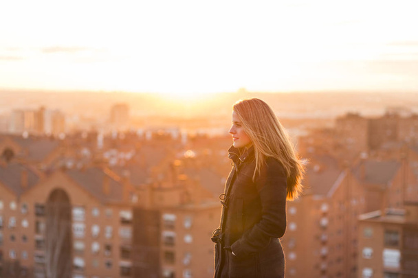 beautiful young woman portrait at sunset. City background - Foto, imagen