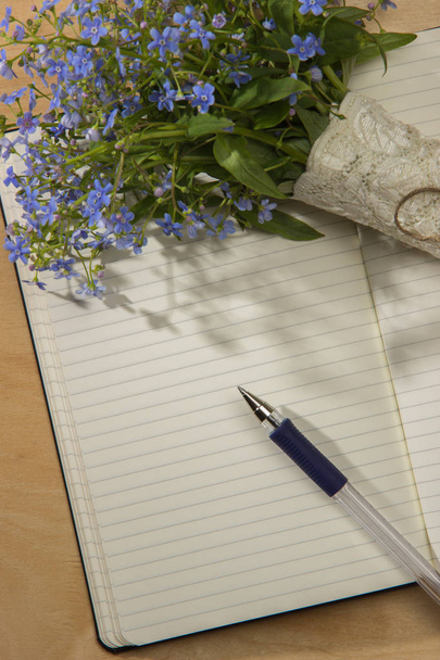 Un ramo de flores me olvidan, cuaderno y pluma en la t de madera
 - Foto, Imagen