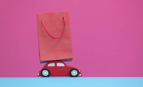  brinquedo carro vermelho e saco de compras
  - Foto, Imagem