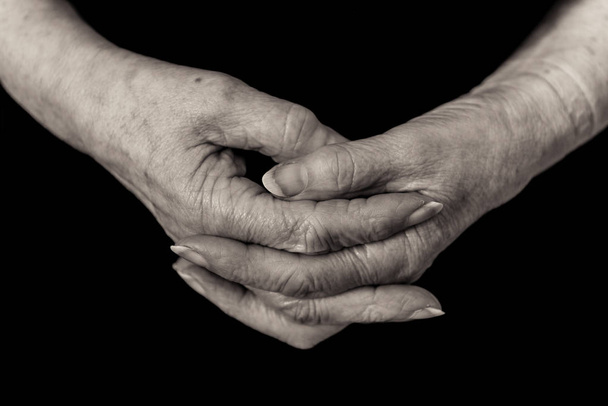 Nahaufnahme eines Rentners, der die Hände zusammenklammert. monochrom. - Foto, Bild