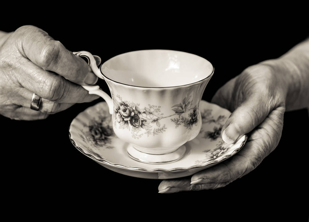 Bir çay fincanı ve tabağı holding bayanın eller İngilizce. Tek renkli. - Fotoğraf, Görsel