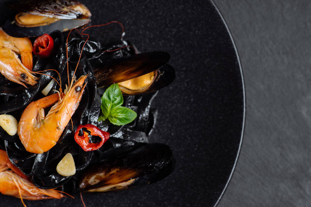 Fresh prawns and mussels on black pasta - Foto, Bild