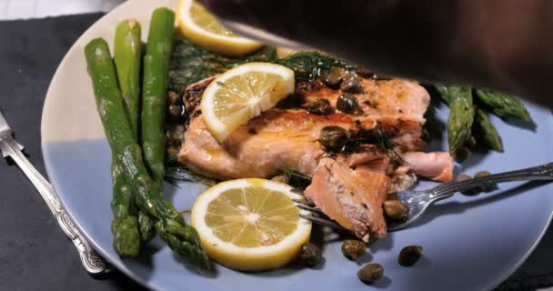 Sprinkling salt over a roasted organic salmon with capers and dill - Footage, Video