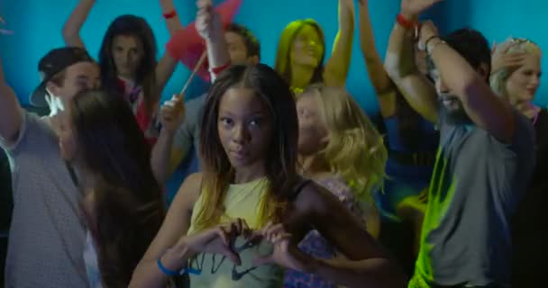 Mujer mostrando el símbolo de la forma del corazón mientras baila con amigos en discoteca
 - Metraje, vídeo