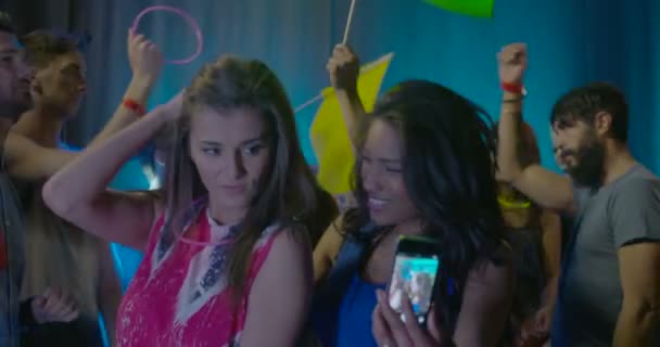 Mujeres tomando fotos de sí mismas y disfrutando de la música mientras bailan con amigos en discoteca
 - Metraje, vídeo