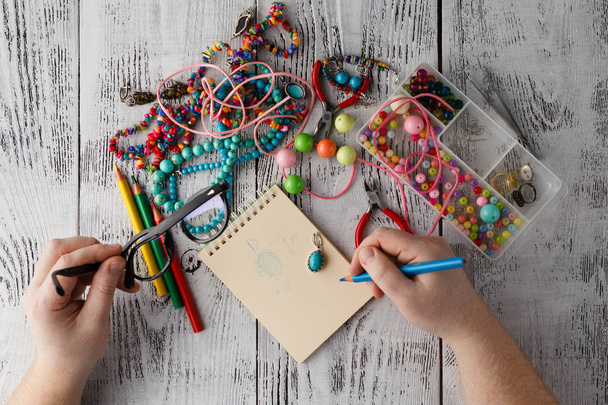 person making earings from colorful beads and needles - Photo, image
