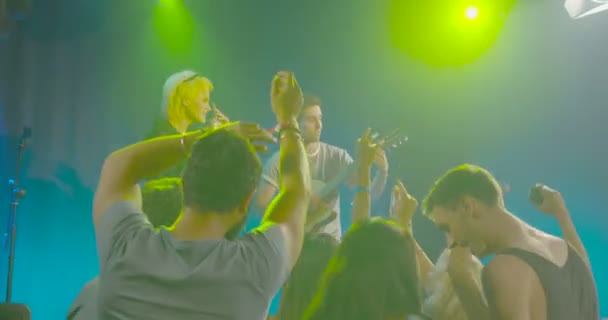 Чоловік і жінка співають і грають на гітарі перед аудиторією в нічному клубі
 - Кадри, відео