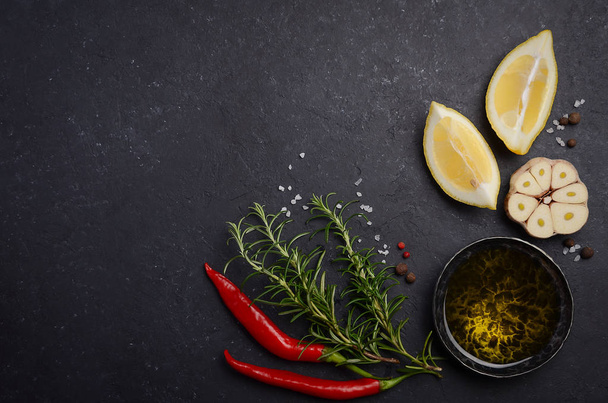 Herbs background - chili pepper, rosemary, garlic, lemon, peppercorn and salt. - Фото, изображение
