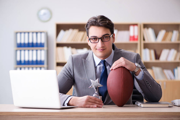 Uomo d'affari con il calcio americano in ufficio - Foto, immagini