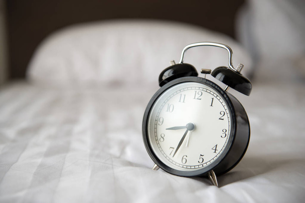 Relógio despertador na cama
 - Foto, Imagem