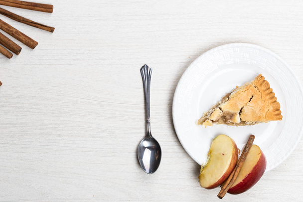Apple pie cake lying on wooden white background with spoon in wo - Zdjęcie, obraz