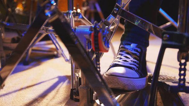 Drummers foot in sneakers moving drum bass pedal - Fotoğraf, Görsel