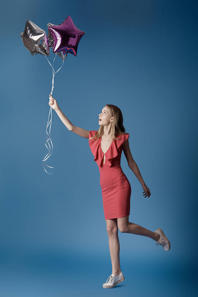 Woman in red dress holding balloons. - Φωτογραφία, εικόνα